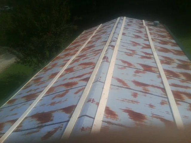 Rusted metal roof panels with new wood purlins before replacement — Storm Damage Roof Repair in Kanab by Roofing Brothers