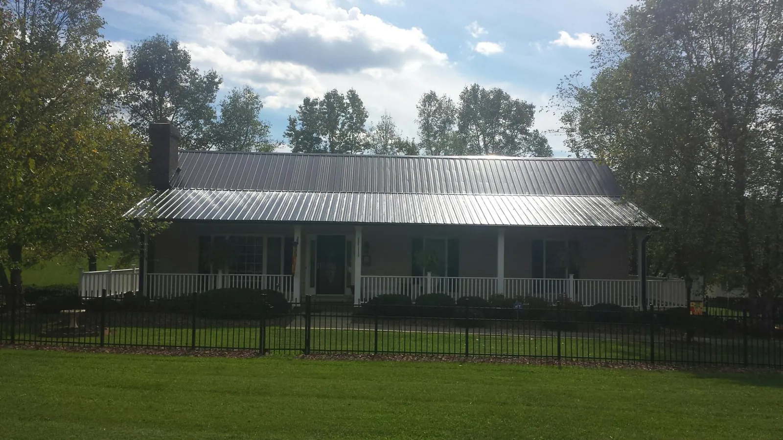 Gray metal roof on a brick ranch with a full width front porch — Gutter Guard Installation work by our crew in Kanab