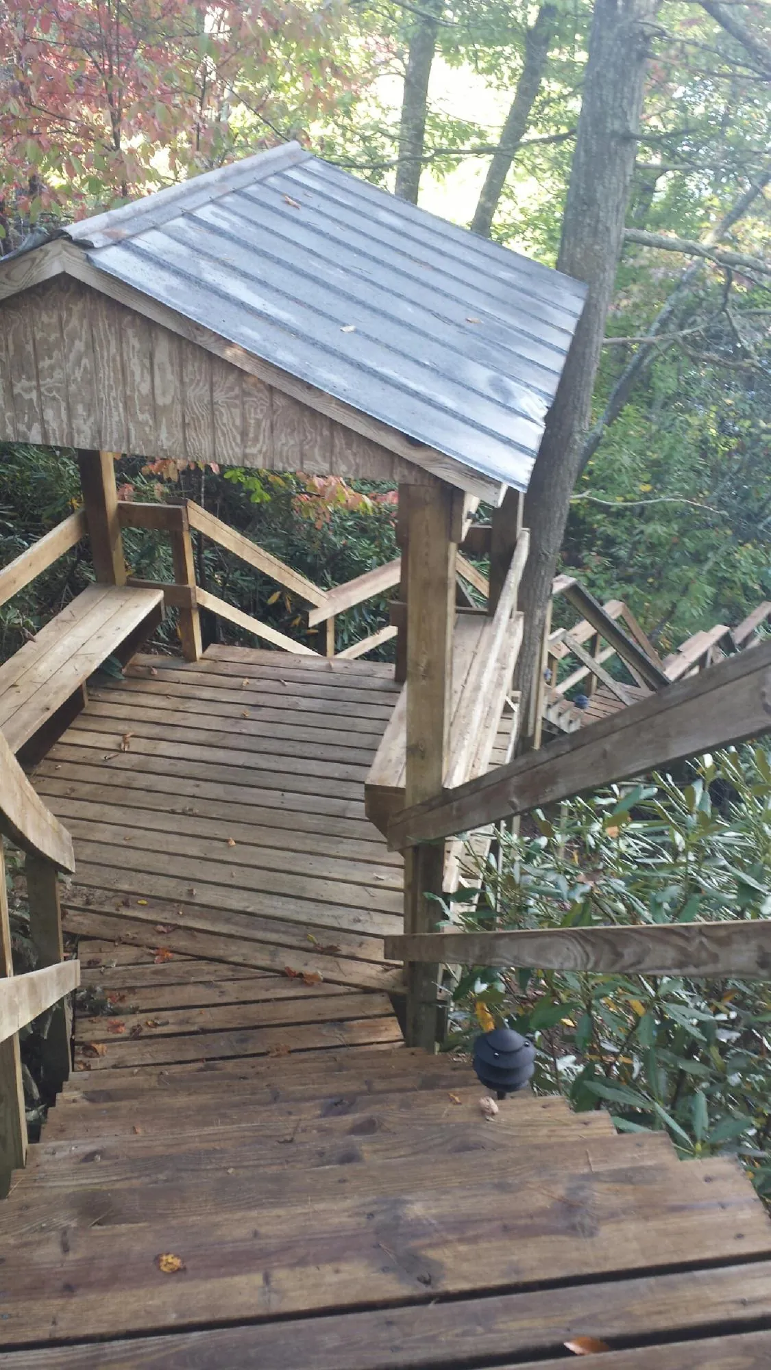 Metal roofed shelter over wooden steps on a wooded walkway — Skylight Repair & Installation work by our crew in Kanab